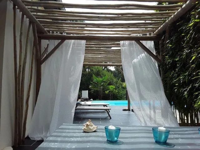 Pergola en rondins d'eucalyptus et voilages — plage de piscine